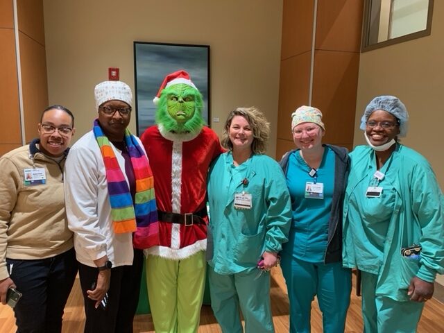 Group of BHFCU employees posing for a photo with the Grinch.