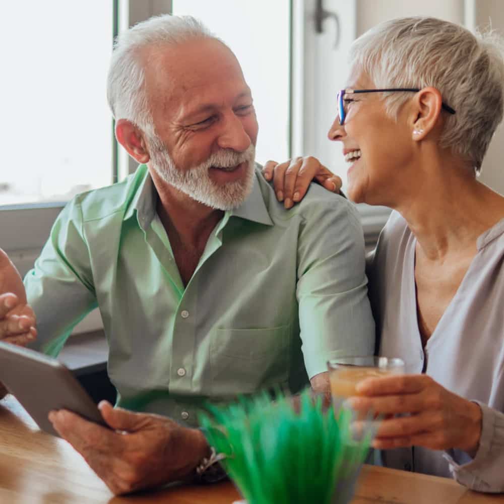 Older couple smiling while having breakfast